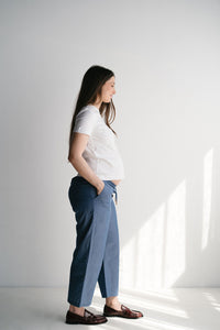 Vue de dos d'une femme enceinte en pantalon de maternité bleu fluide