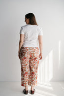 Femme enceinte en pantalon imprimé et haut assorti dans un décor naturel