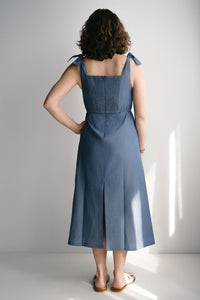Portrait d'une femme souriante en robe de maternité bleue élégante
