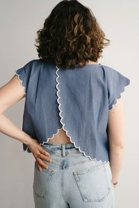 Vue de dos d'une femme en blouse d'allaitement bleue avec détail brodé et festonné