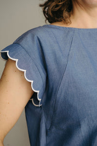 Femme en haut d'allaitement bleu dans un décor extérieur ensoleillé
