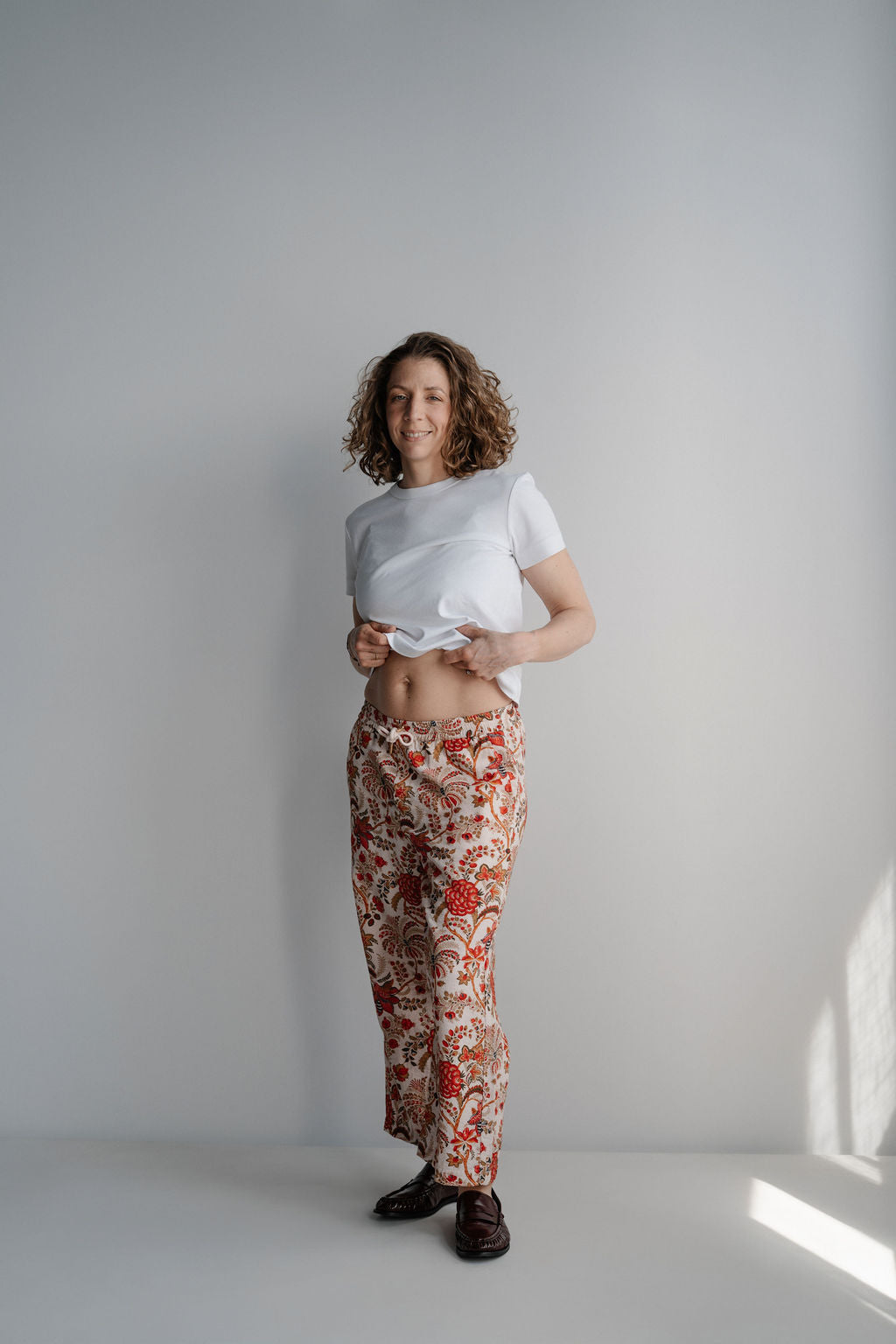 Portrait d'une femme enceinte souriante en tenue de maternité imprimée bohème