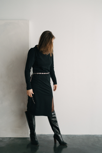 femme en robe contre un mur.