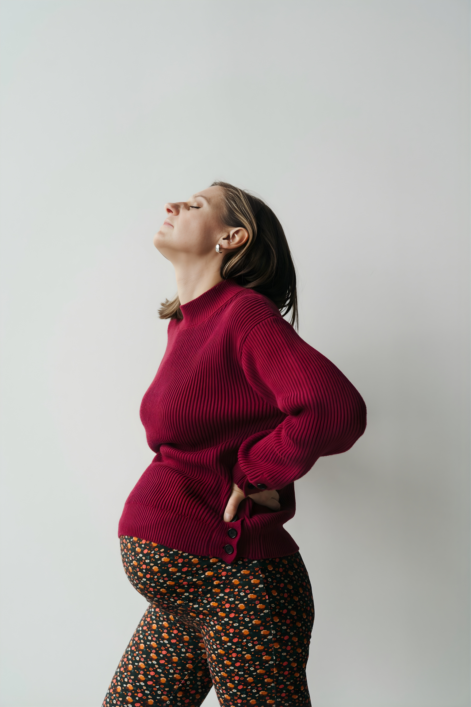 Femme enceinte qui se masse le dos et porte un chandail de maternité