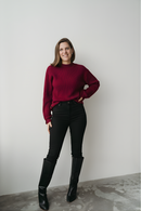 Femme qui porte un chandail bordeaux avec boutons sur le coté