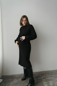 femme en chandail de maternité noire