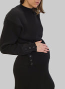 femme qui porte une robe et un pull noire de maternité en maille de coton