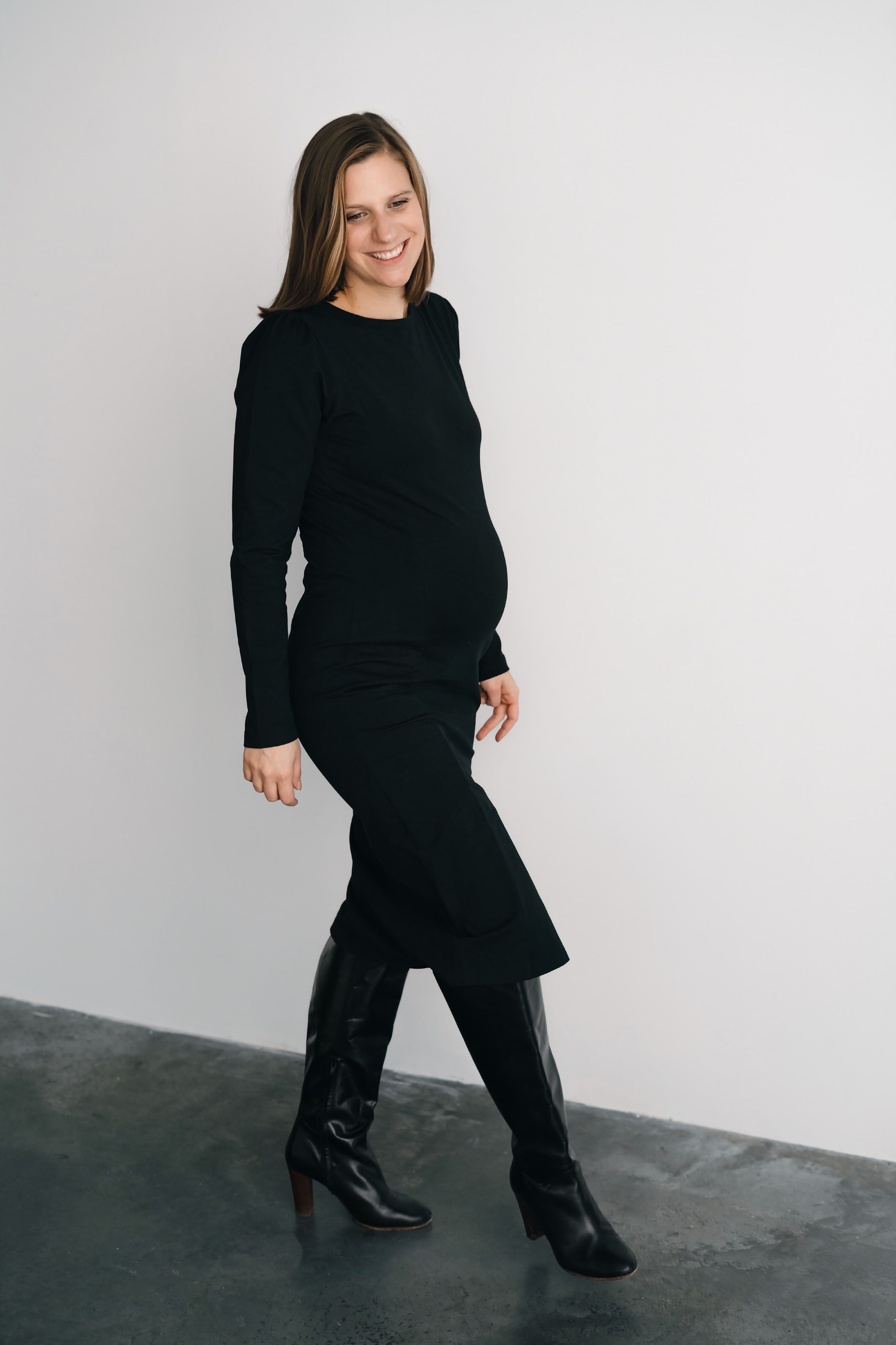 Femme qui marche en jupe et chandail de maternité