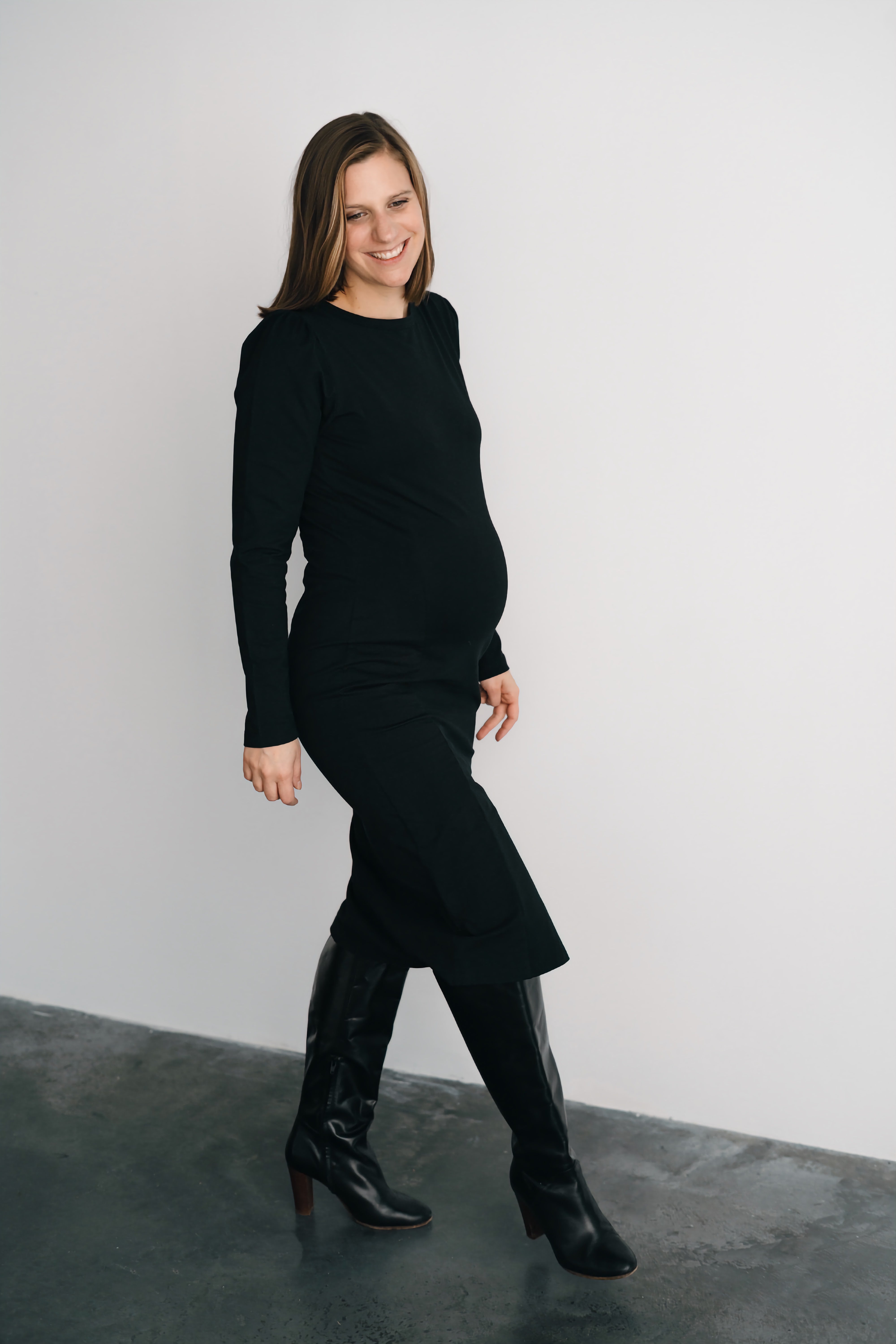 Femme qui marche en jupe et chandail de maternité