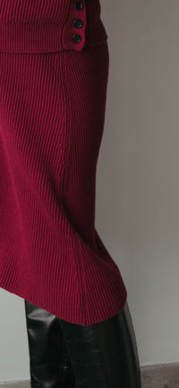 femme qui porte un jupe bordeaux avec des bottes en cuir