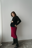 Femme qui touche son ventre de grossesse en jupe de maternité