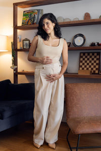 Femme enceinte qui porte un pantalon de maternité beige et fluide