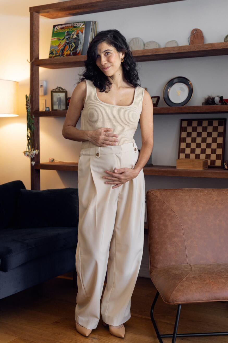 Femme enceinte qui porte un pantalon de maternité beige et fluide