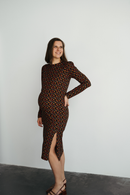 Femme enceinte qui porte une robe de maternité fleurie et sourit